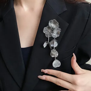 Vista dettagliata dell'elegante spilla a fiori traforati in argento con strass