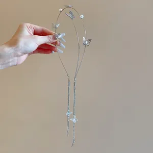 Detail of elegant silver headband with rhinestone butterflies, faux pearls and long tassels