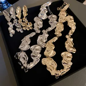 Macro detail of an irregular melted-metal jewelry set in gold and silver plated finishes