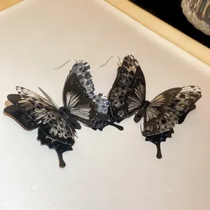 Exquisite 3D butterfly ear hooks featuring layered black and spotted acrylic wings