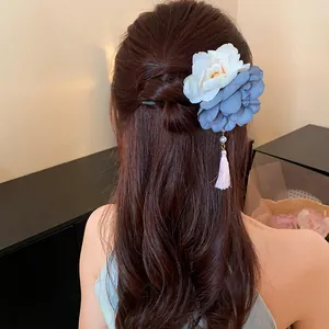 Detailansicht einer floralen U-Haarnadel mit Perlenquaste auf elegantem Flechthaar