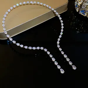 Vue détaillée d'un collier luxueux en zircons en forme de goutte sur surface sombre.