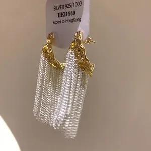 Dettaglio ravvicinato di orecchini a nappa a forma di C plissettati con ago in argento