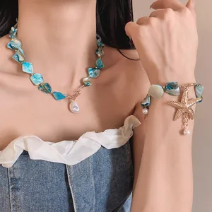 Detalle de collar y pulsera de perlas de concha y estrella de mar natural en modelo
