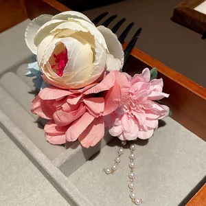 Detailaufnahme einer chinesischen Haarnadel mit Stoffblumen und Perlenanhängern
