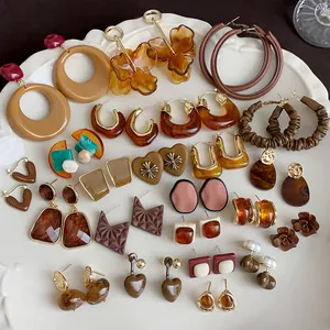Collection of vintage Maillard brown heart earrings and amber resin studs on a white plate