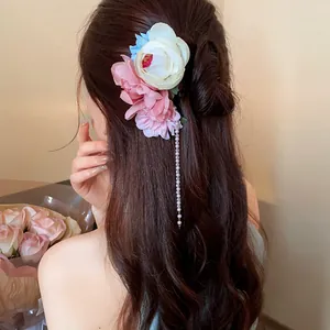 Detailansicht einer eleganten floralen Haarnadel mit Perlenquasten in einem Dutt