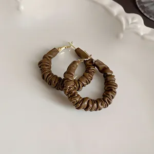 Macro detail showing the unique ruched dark brown leather texture of these hoop earrings