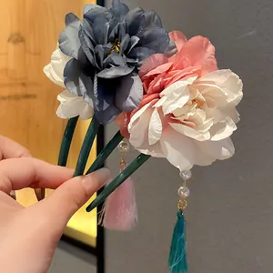 Detailansicht eleganter U-förmiger Haarnadeln mit Stoffblumen und Perlenquasten