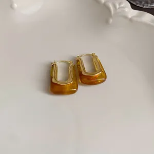 Detailed close-up of vintage Maillard brown U-shaped hoop earrings with polished gold trim