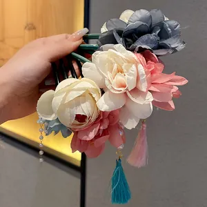 Nahaufnahme von eleganten Haarspangen im chinesischen Stil mit Blumen, Perlen und Seidenquasten