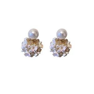 Eleganti orecchini a lobo con fiori e perle dal design vintage su sfondo bianco.