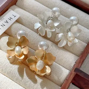 Macro detail of French retro flower earrings with elegant pearls in a jewelry tray