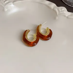 Close-up of vintage heart-shaped resin earrings in coffee color with gold accents