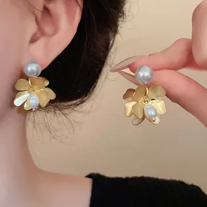 Macro view of French vintage gold flower earrings featuring freshwater pearls