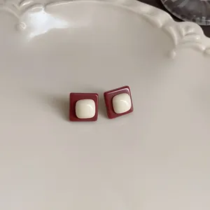 Close-up detail of vintage square stud earrings in Maillard brown and cream white finish