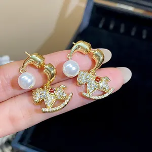 Detailed close-up of exquisite rocking horse earrings featuring pearls and rhinestones