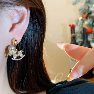 Close-up of elegant 18K gold plated rocking horse earrings with pearls and crystals