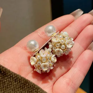 Vista dettagliata di eleganti orecchini a lobo con fiori di perle e accenti in strass