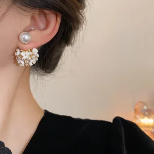 Primo piano di eleganti orecchini a lobo con fiori e perle che mostra i dettagli delicati