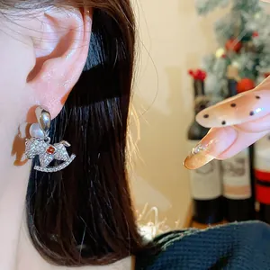 Close-up of 18K gold plated rocking horse earrings featuring pearls and sparkling rhinestones.
