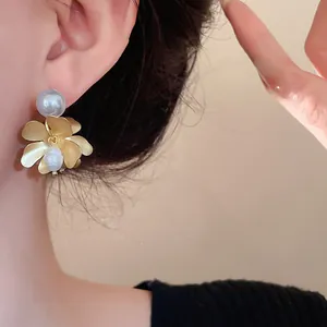 Detailed view of elegant French vintage flower earrings with freshwater pearls on a female model