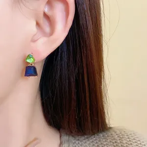 Nahaufnahme von Vintage-Ohrringen mit grünen und blauen trapezförmigen Kristallen