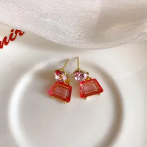 Detaillierte Ansicht der rosa und roten trapezförmigen geometrischen Strassohrringe