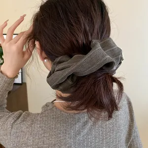 Close-up of retro striped fabric headband worn by a model in a stylish bun style