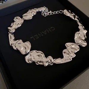 Close-up of irregular silver geometric metal necklace in black gift box