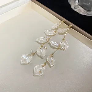 Close-up detail of elegant pearl lily of the valley dangle earrings with golden hooks