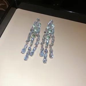 Elegant silver tassel earrings with blue and green oval zircons in a light luxury style.