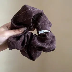 Close-up of a vintage brown striped fabric scrunchie showing detailed texture and design