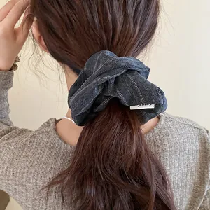 Detailed shot of a vintage striped fabric scrunchie on a ponytail for women's hair accessory