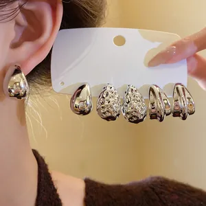 Primo piano di un set di orecchini a goccia placcati in argento con vari design e finiture.