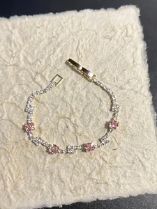 Vista dettagliata dell'elegante bracciale con zirconi rosa su carta