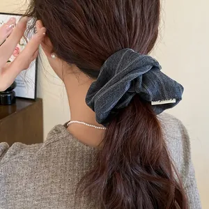 Back view of a model wearing a grey striped fabric scrunchie for a vintage hairstyle