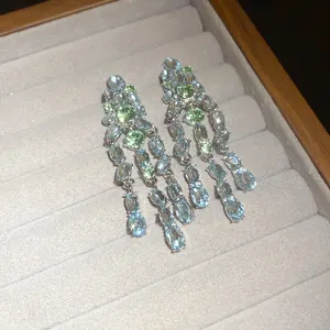 Exquisite oval light blue and green zirconia tassel earrings on velvet jewelry display