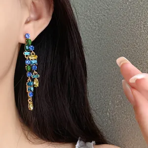 Exquisite close-up of vibrant zircon tassel earrings with multi-color stones on a model's ear