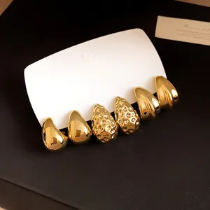 Primo piano di set orecchini placcati oro con texture a goccia, martellata e a coste