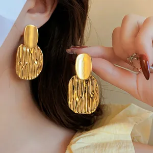 Elegant vintage gold-toned geometric drop earrings featuring a textured metal finish