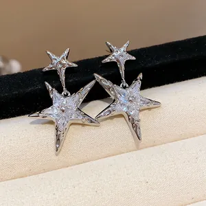 Detailed close-up of sparkling silver star-shaped stud earrings with clear zircon stones