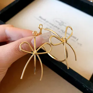 Close-up of gold-plated bow knot hoop earrings with elegant ribbon design