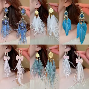 Detailed view of various bohemian feather tassel earrings with rhinestone bow accents