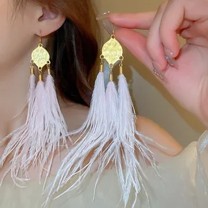 Elegant Bohemian retro long feather tassel earrings with pale pink feathers and gold metal detail.