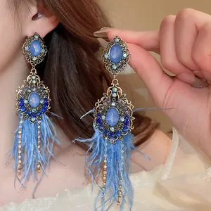 Detailed close-up of Bohemian vintage blue feather tassel earrings with stones