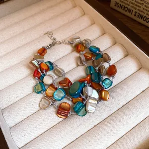 Detail shot of bohemian multi-layer bracelet with colorful irregular shells in jewelry box