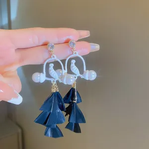 Bohemian feather tassel earrings with white bird and pearl detail on crystal studs