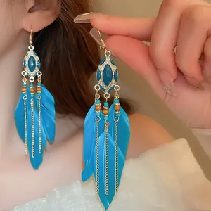 Detailed close-up of bohemian retro blue feather tassel earrings with turquoise beads