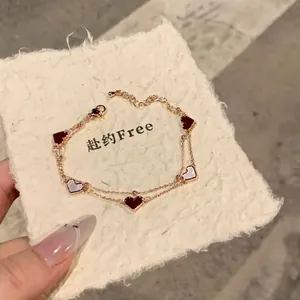 Κομψό χρυσό βραχιόλι διπλής σειράς με κόκκινες και λευκές καρδιές από φίλντισι.